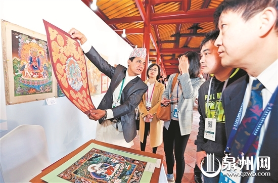 尼泊尔艺人向参观者展示唐卡
